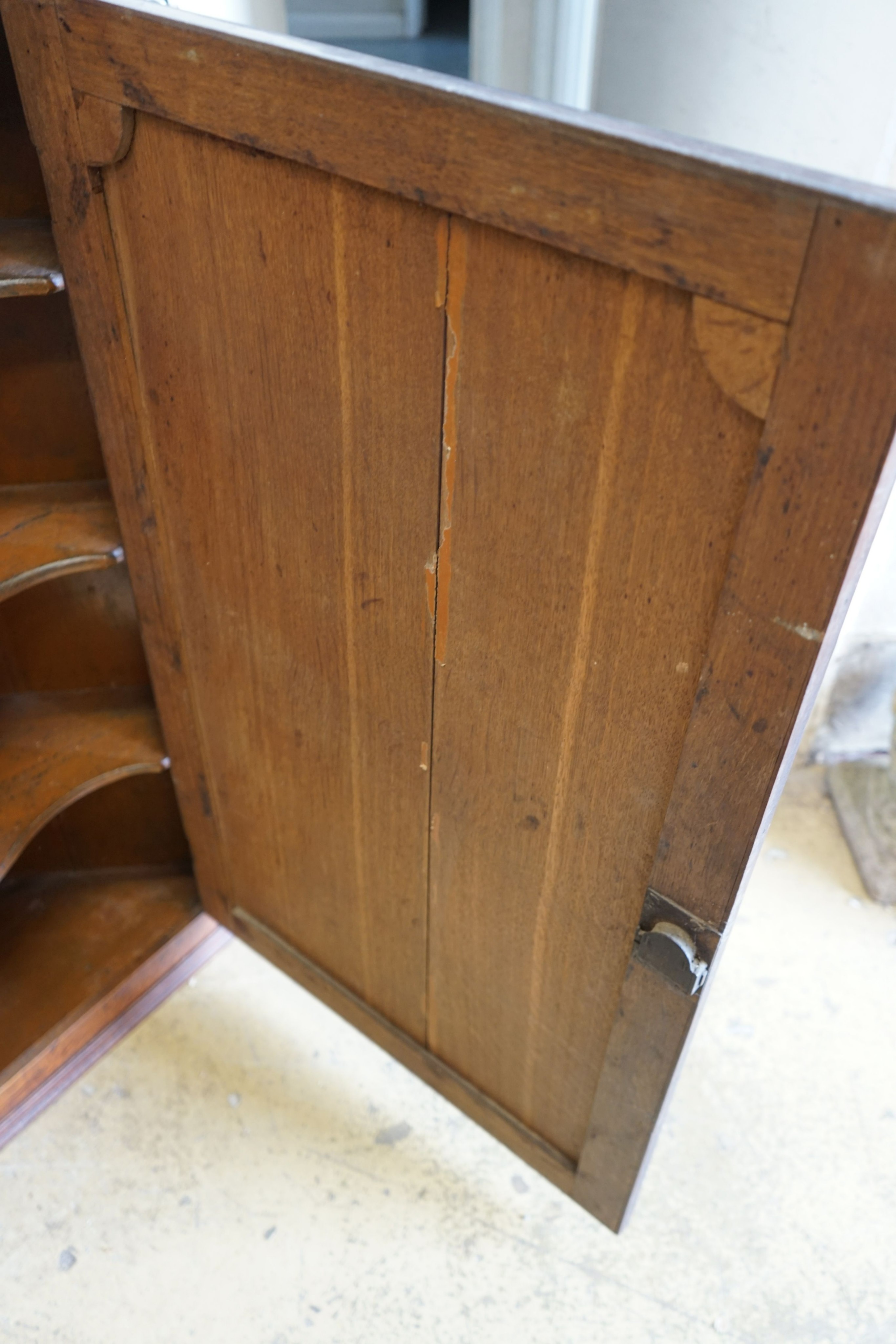 A George III oak hanging corner cabinet, width 85cm, depth 47cm, height 127cm